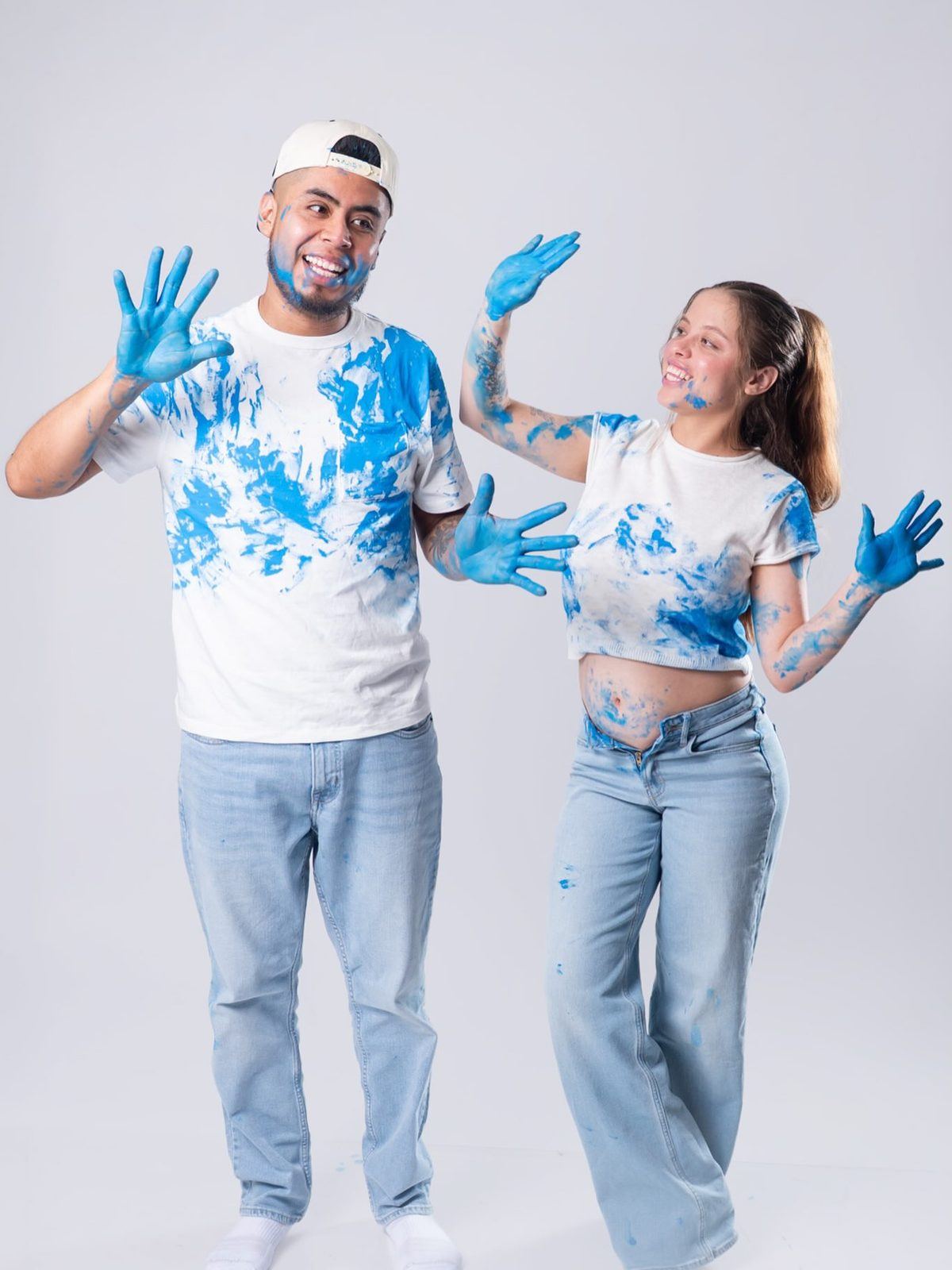 Gender-reveal couple covered in blue paint