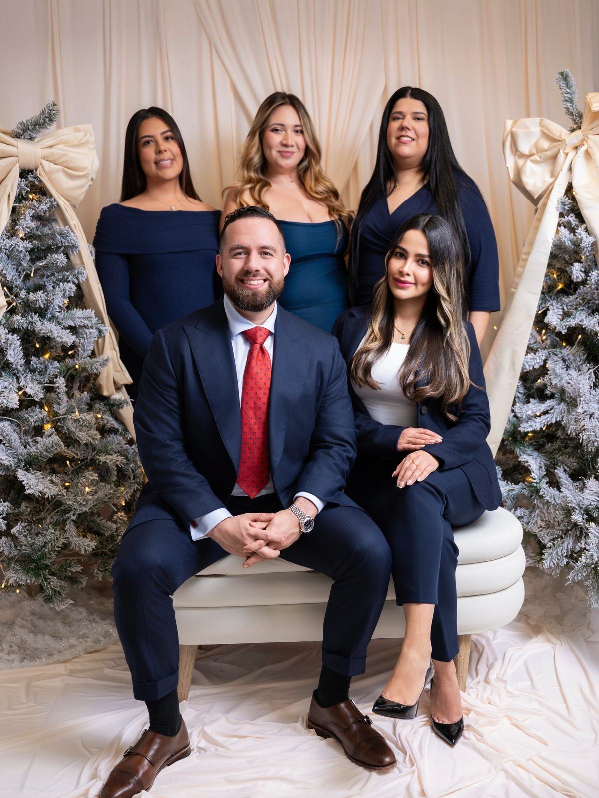Holiday team portrait between flocked trees