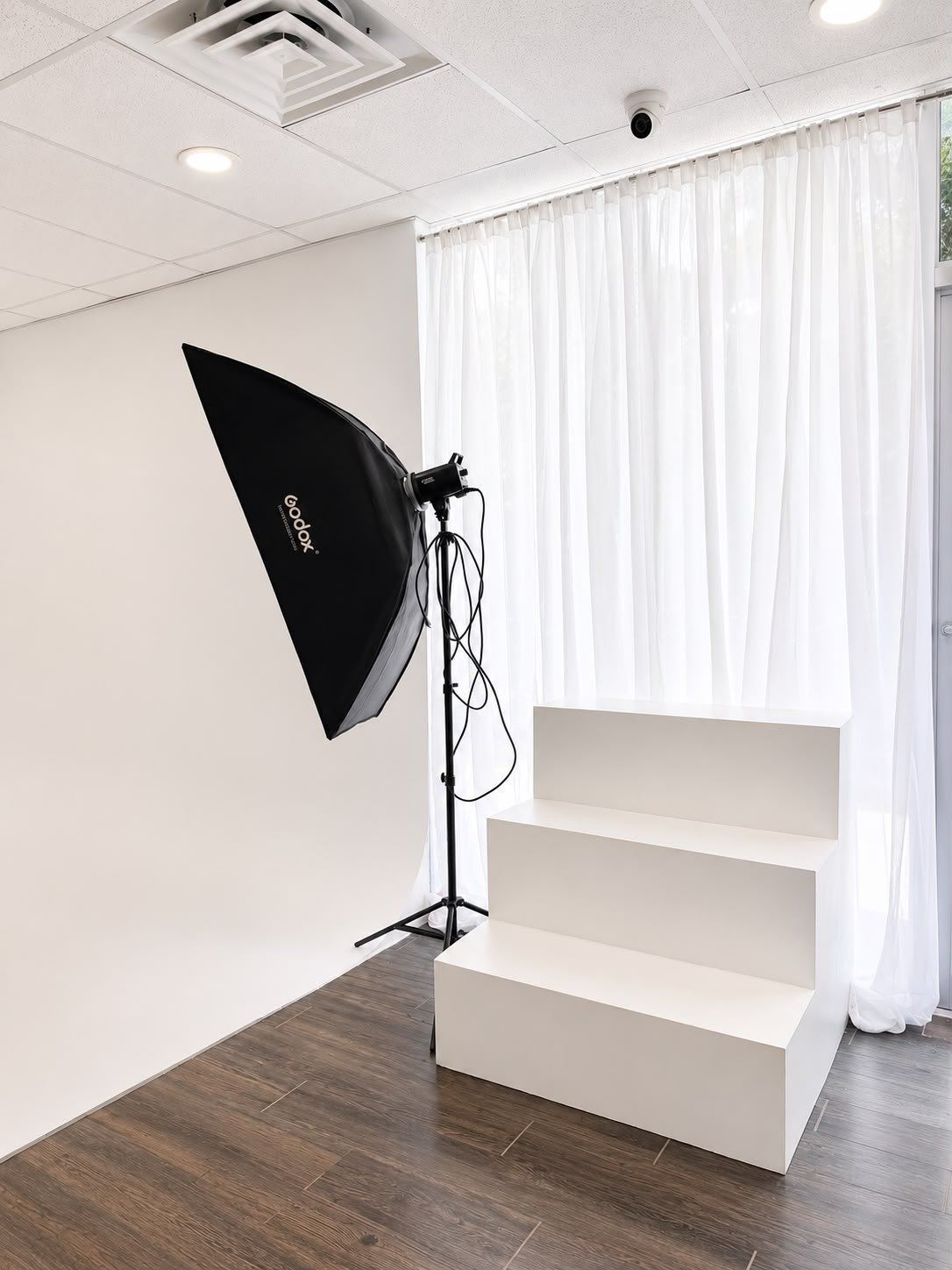 Infinity wall with posing stairs, sheer drapes, and a Godox octabox